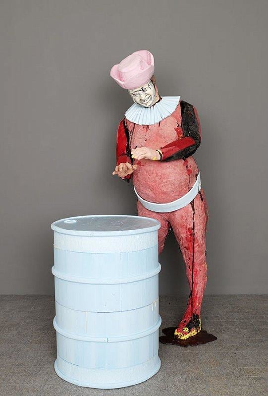 happy statue holding out his hands over a barrel as if warming them over a fire