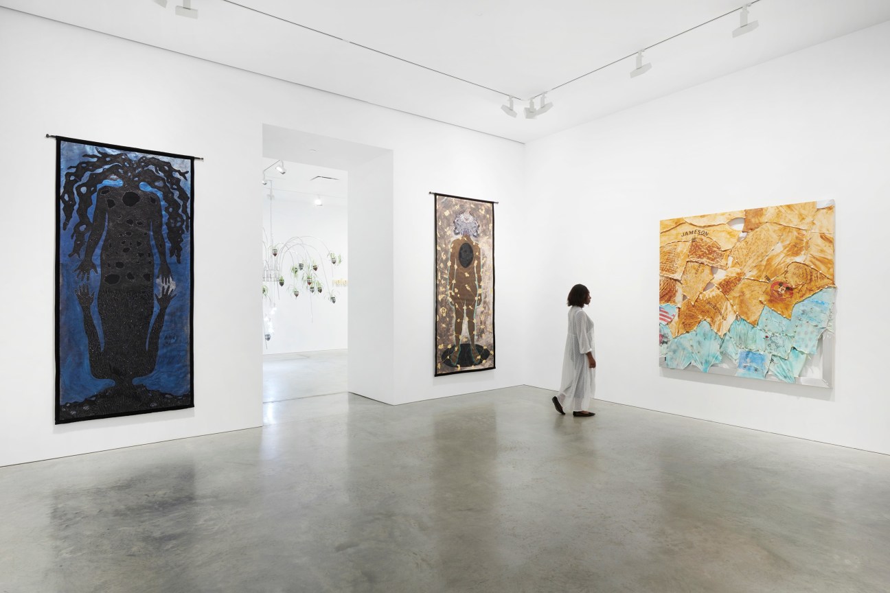 gallery view of three artworks and an entryway to another room with more art