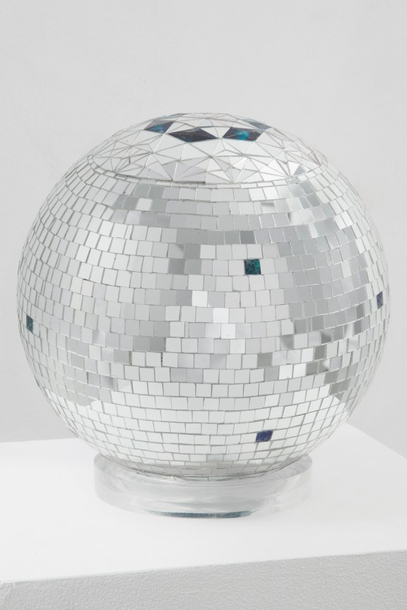 Discoball made of reverse glass on white pedestal by Monir Shahroudy Farmanfarmaian.