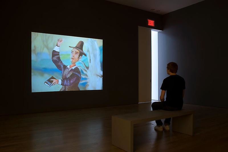 man sitting looking at video