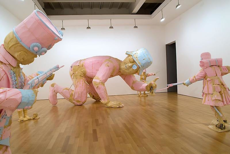 installation view of lots of statues, including a giant one