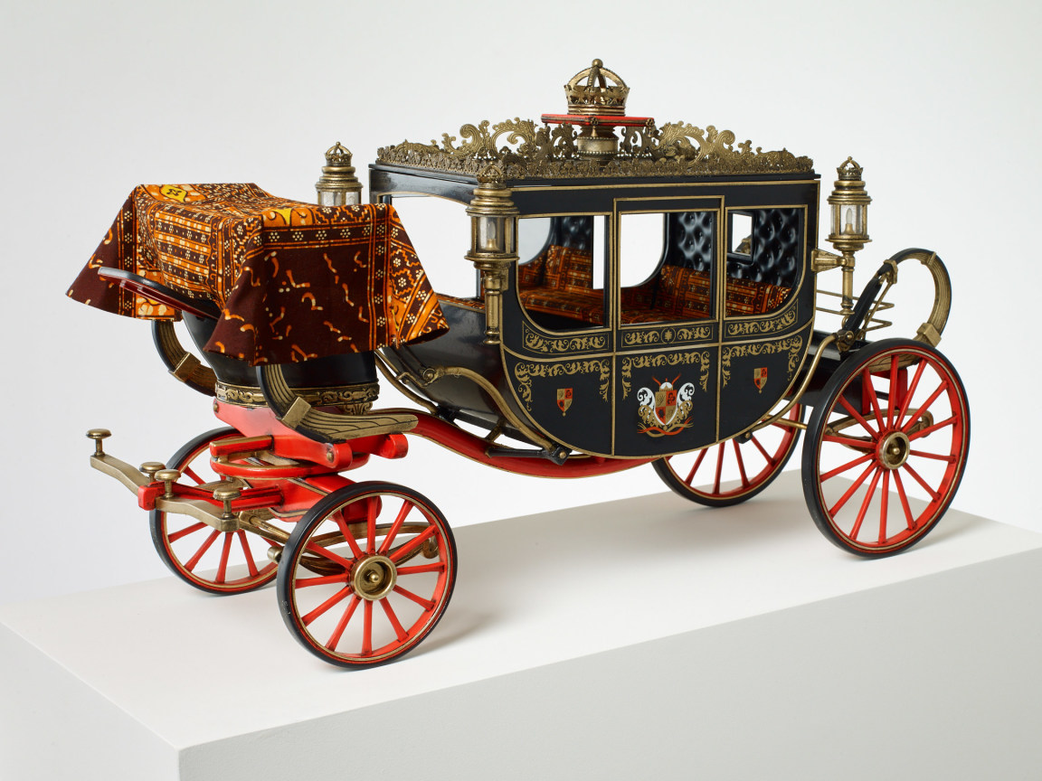 beautiful brown carriage with red wheels and golden detailing