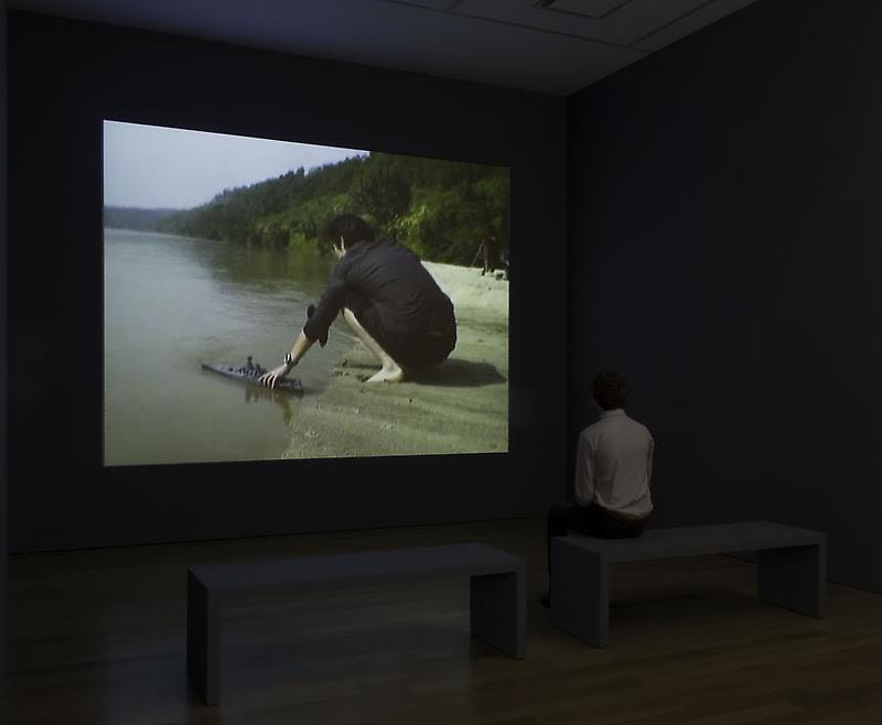 A person seating in front of a film screening of &quot;18 Days.&quot;