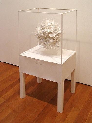 white art piece in a glass casing