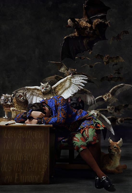 white man asleep on his desk with several animals behind him