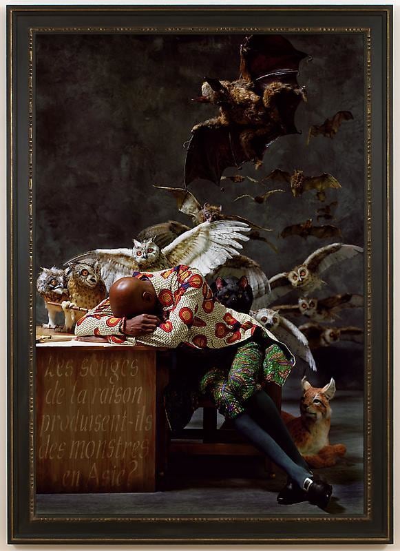 black man asleep on his desk with several animals behind him