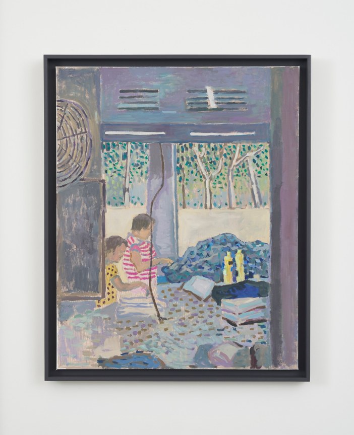 two people sewing indoors in front of a large pile of fabric