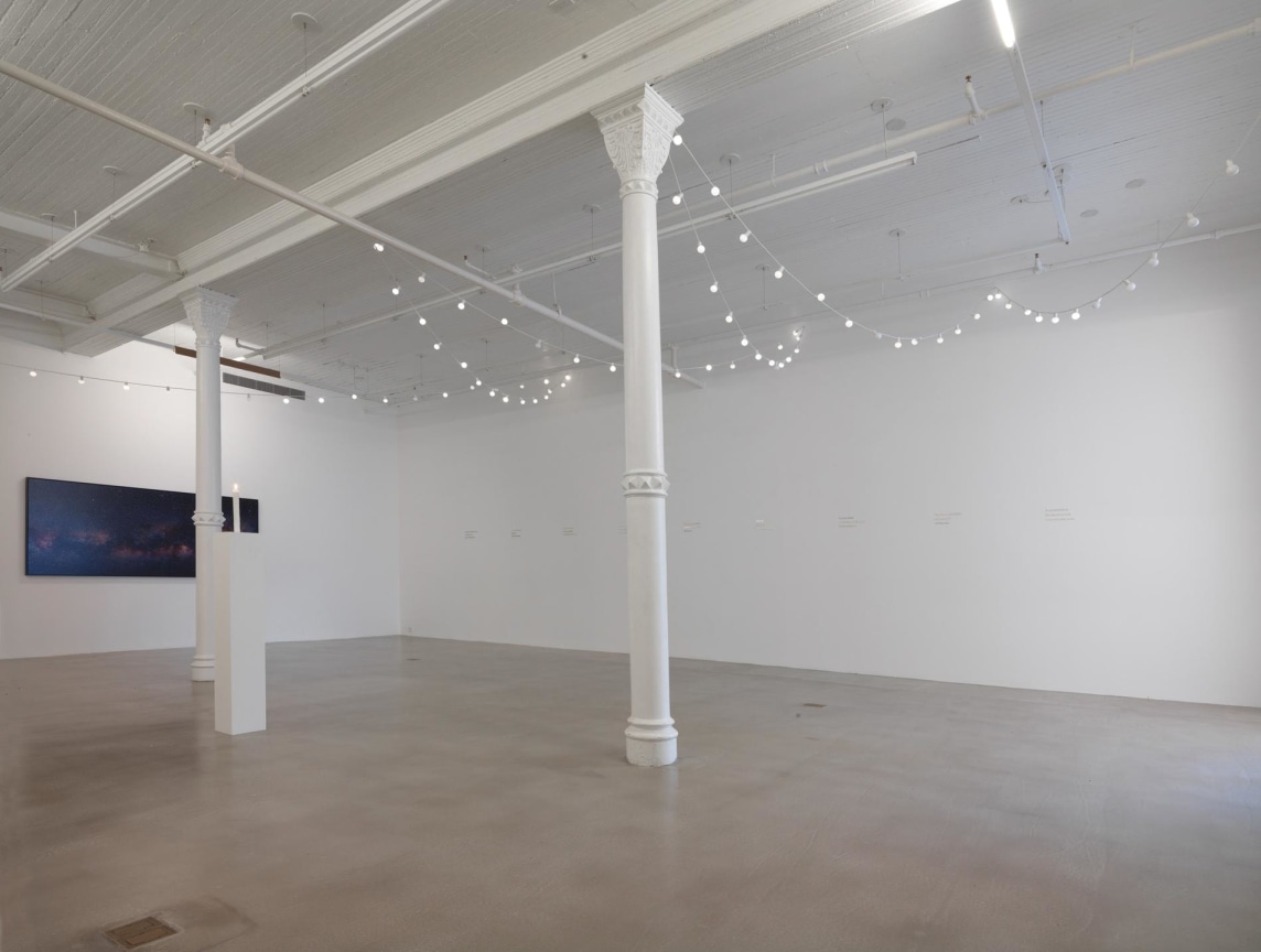 installation view of string lights and another artwork