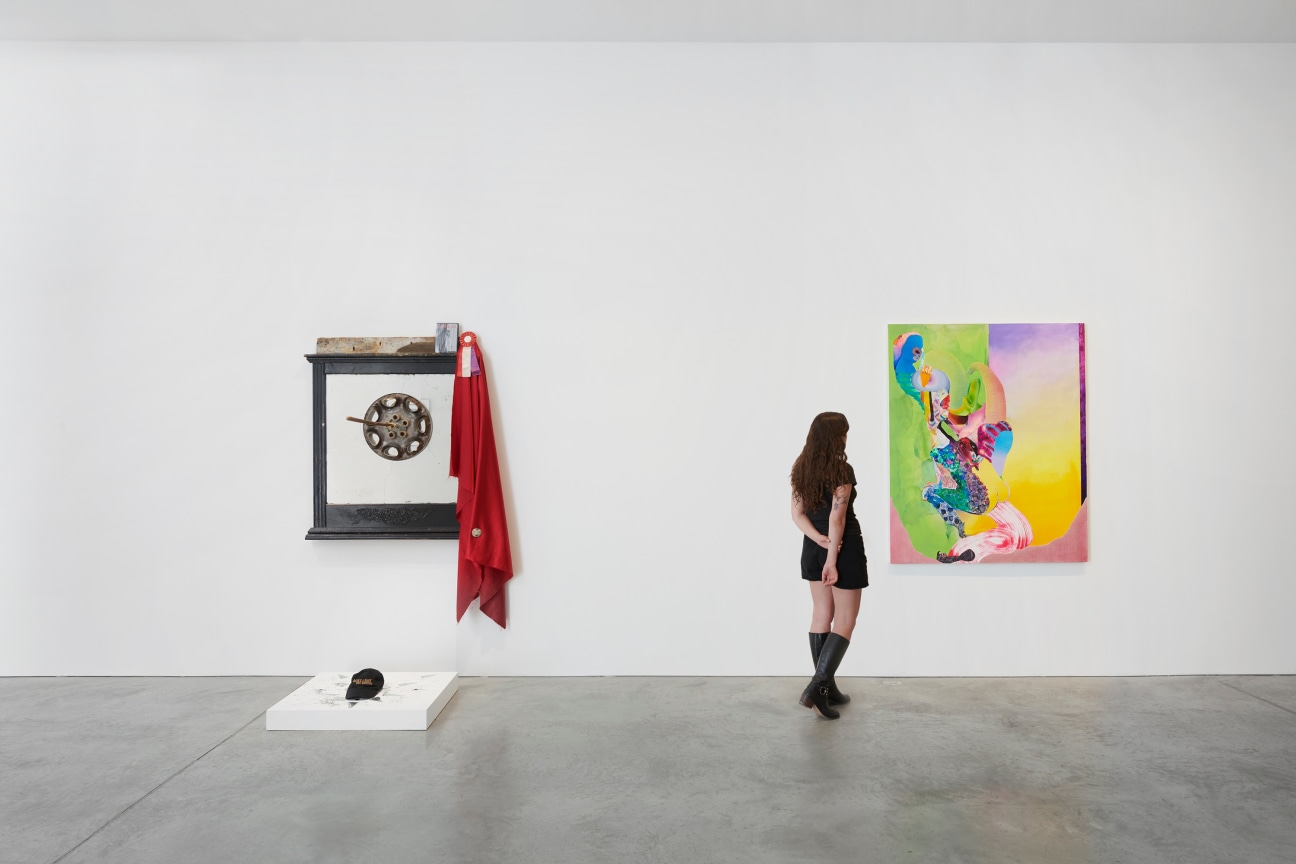 person looking at a painting next to an installation