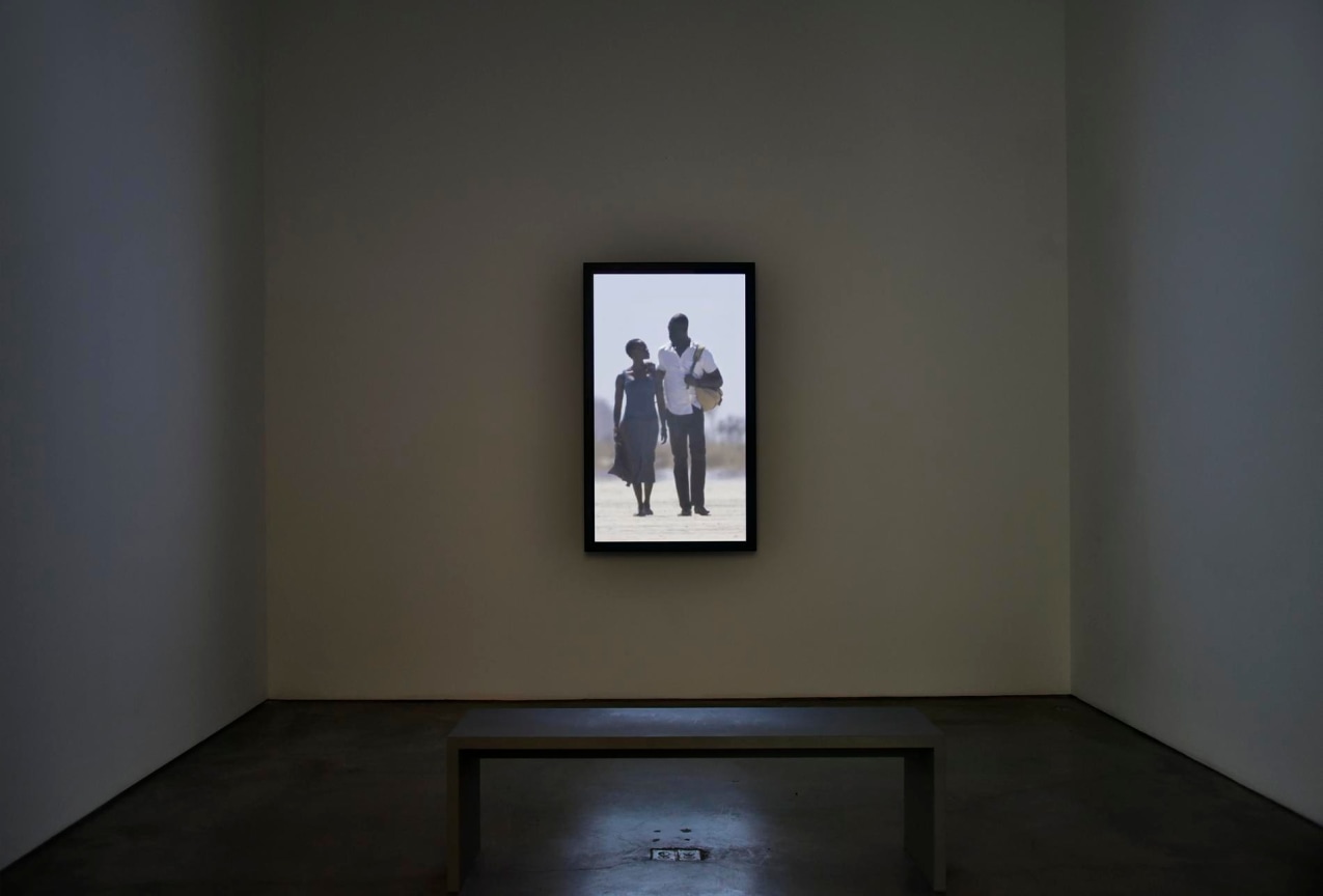 installation view of a video of a couple walking and looking at each other