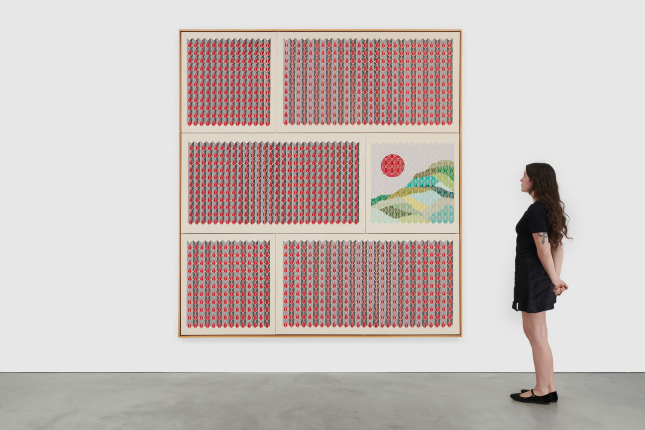 Installation view of a red hand embroidered artwork with a woman observing from the right