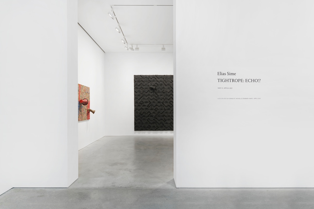 entrance into exhibition with a view of two artworks