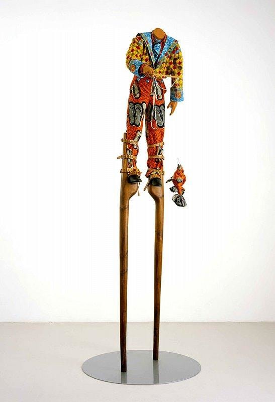 headless mannequin on stilts holding a fishing rod with a catch