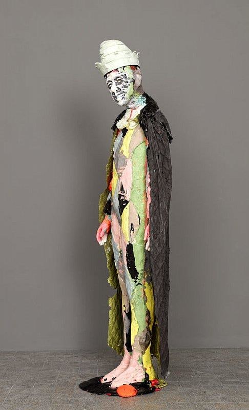 smiling statue with a long black cape reaching his ankles