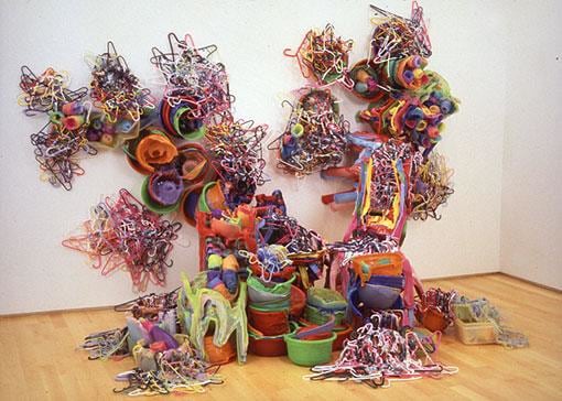 multicolor sculpture made of plastic, almost crawling up the walls