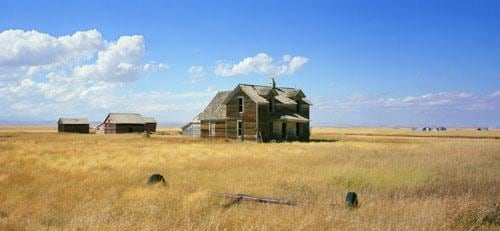 wooden home and farmland in the middle of a field