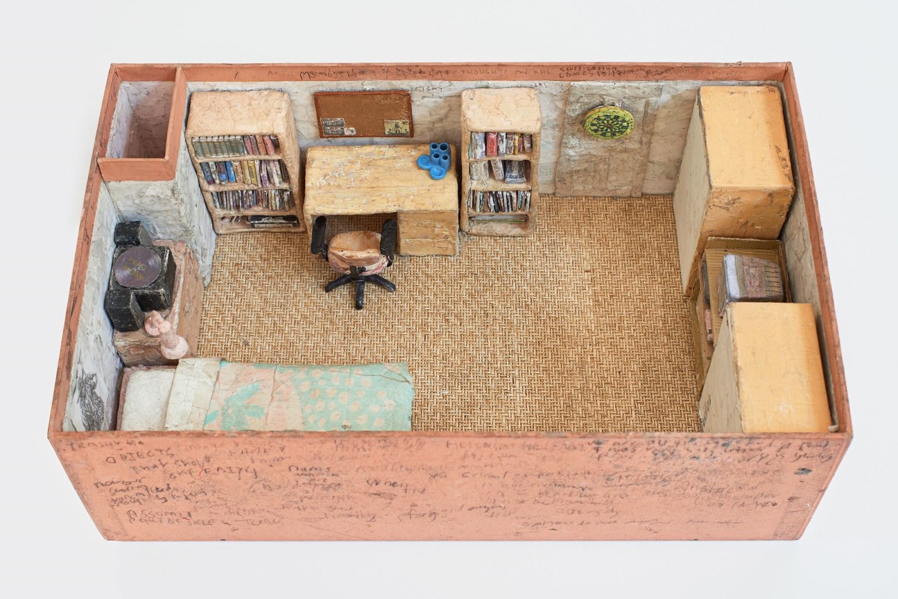 A miniature of a bedroom with scribbles on its pink facades