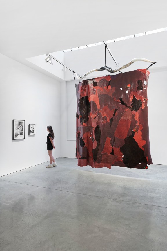 person looking at two smaller artworks