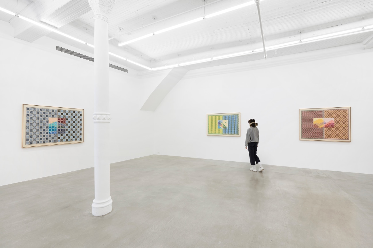 figure walking through white gallery with three embroidered artworks