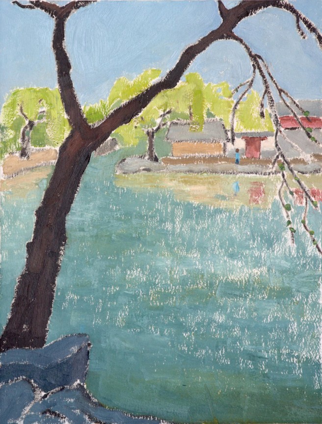 a tree with very few leaves looking over a river with a building right across from it