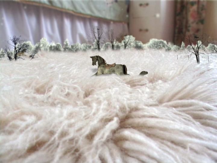 wooden horse running through fluffy towel