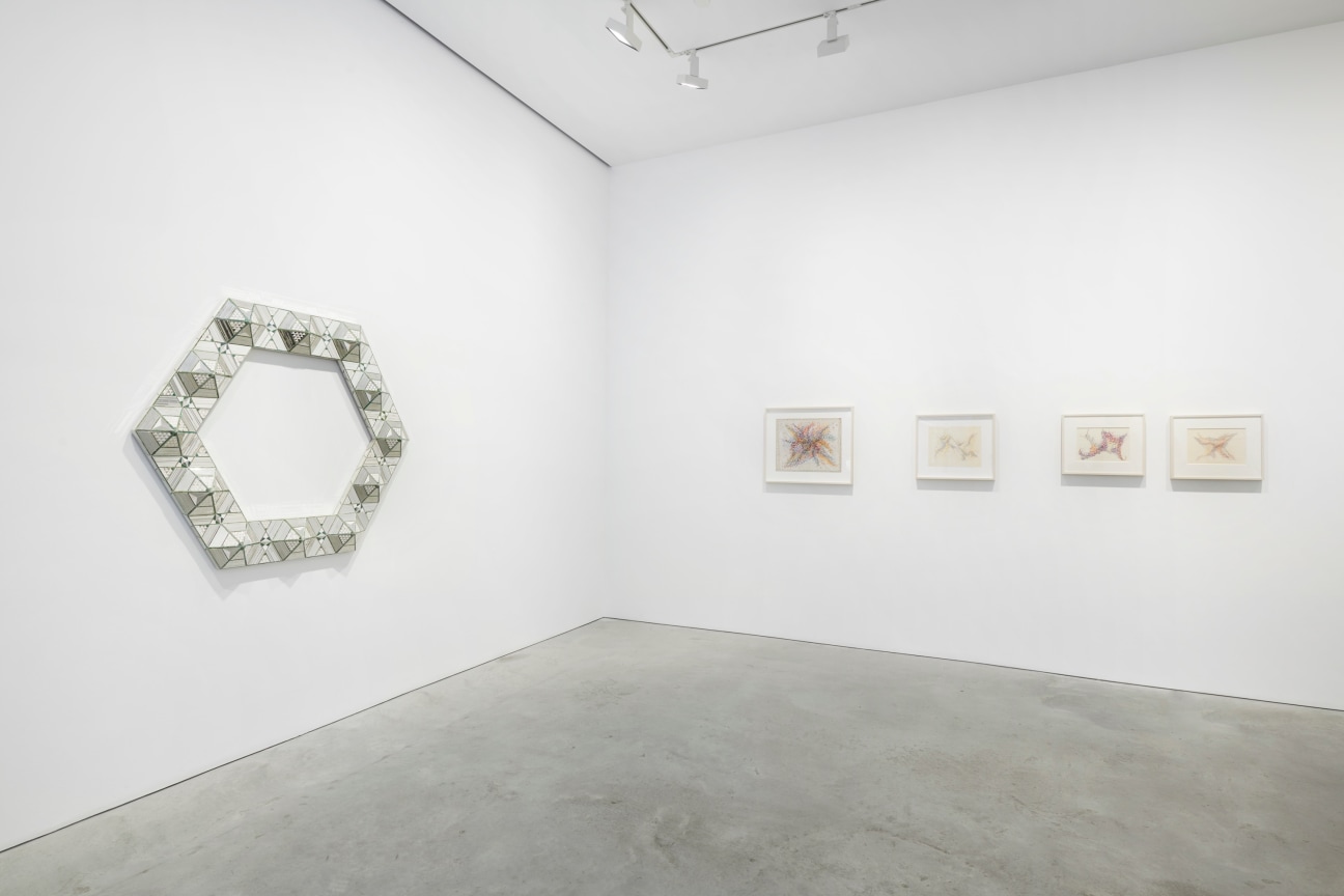 hexagonal glass work next to four abstract drawings