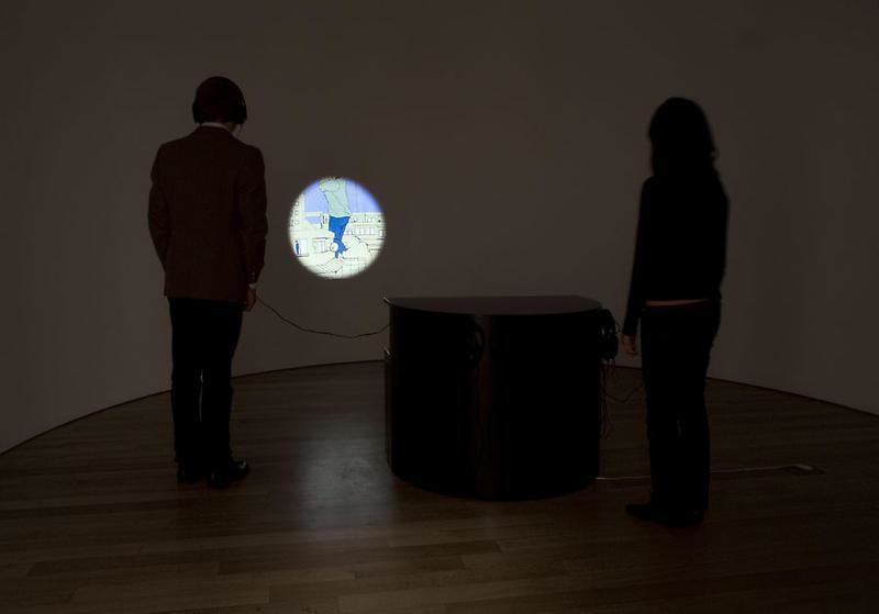 people looking at a circle revealing a city