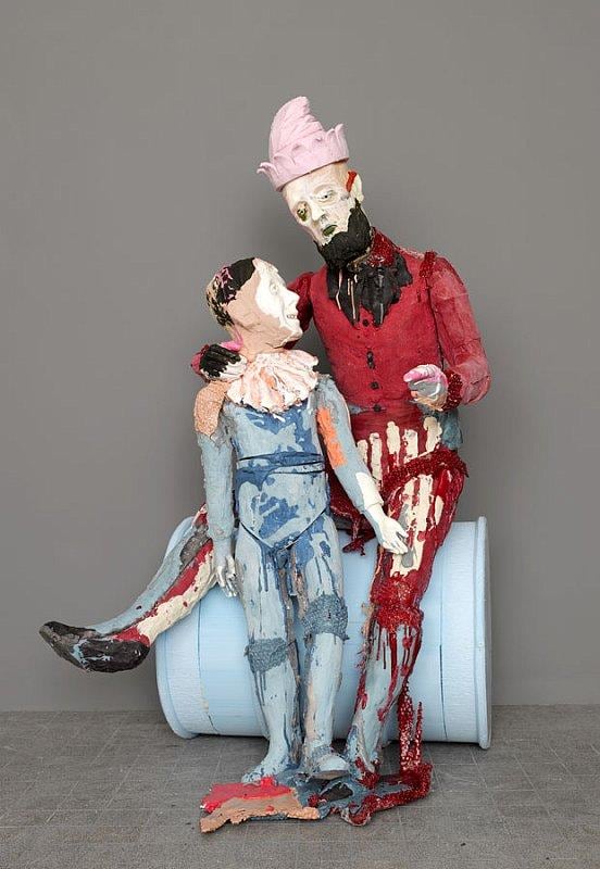 a father and son statue sitting on a metal barrel