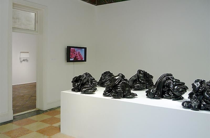 installation view of black blobs of paint on a table