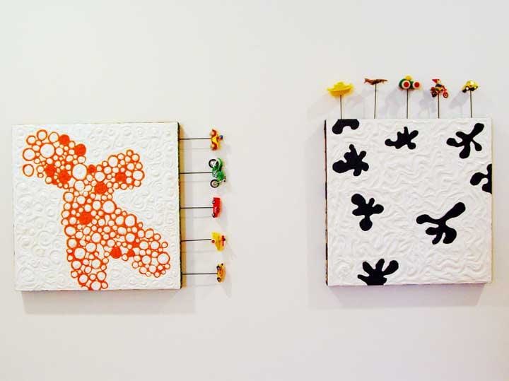 abstract paintings with small toys attached to the borders
