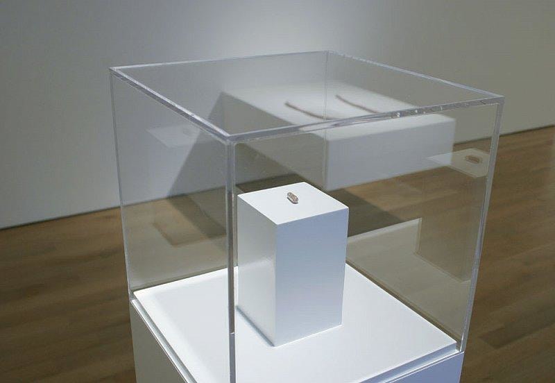 tiny pill encased in glass display case