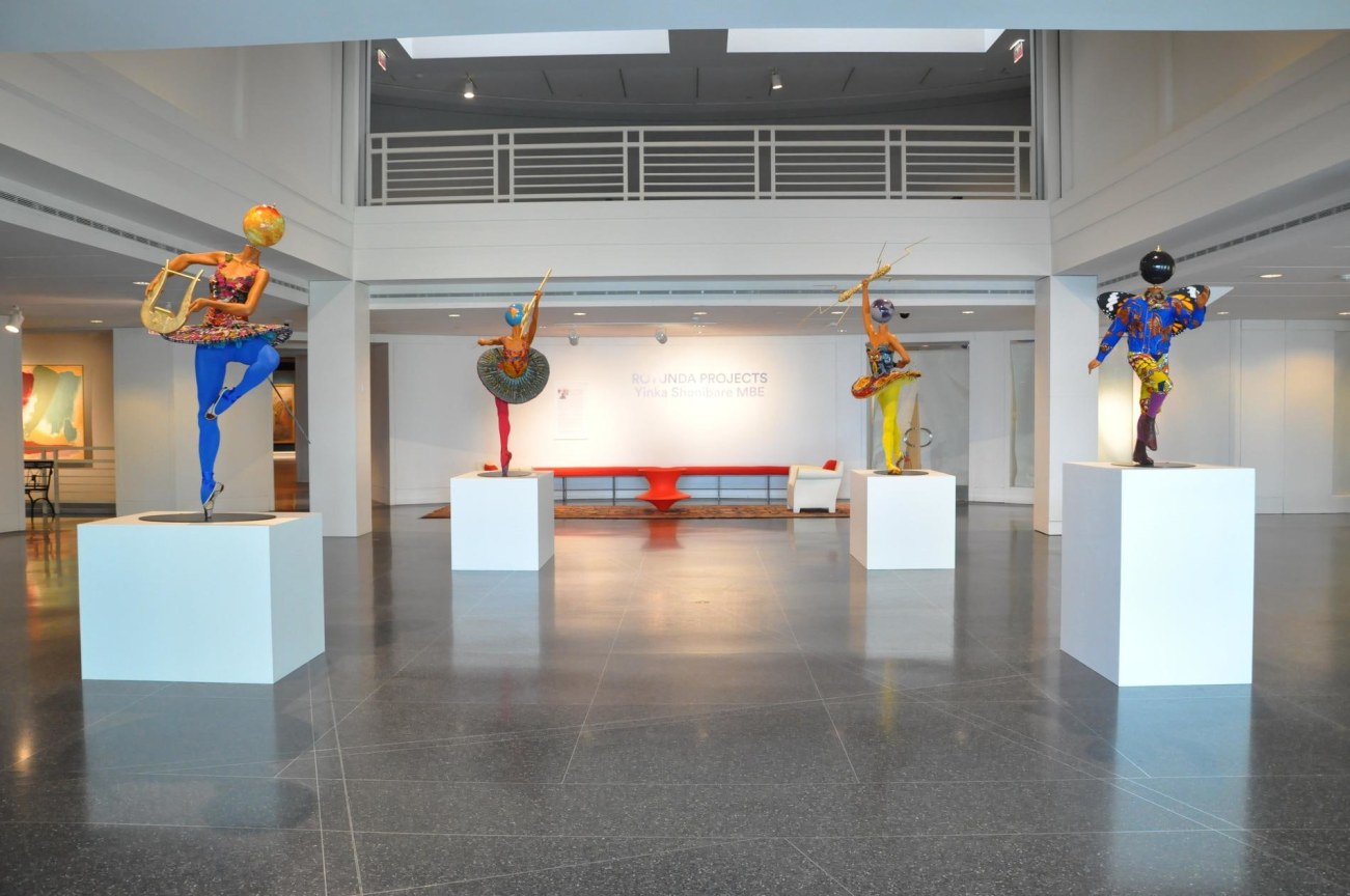 installation view of mannequins with globes for heads dancing ballet
