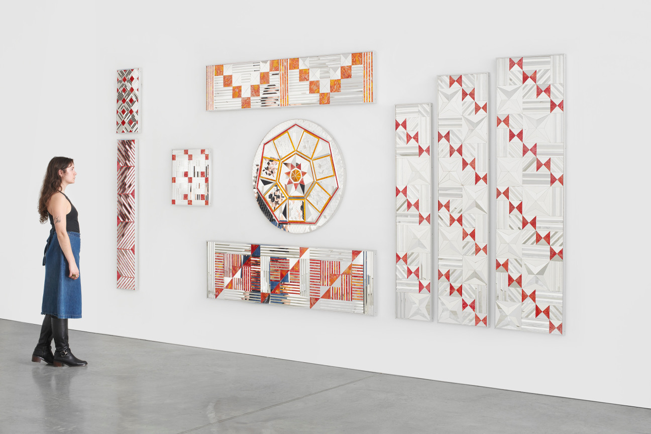 a person observing nine glass pieces that make up one artwork