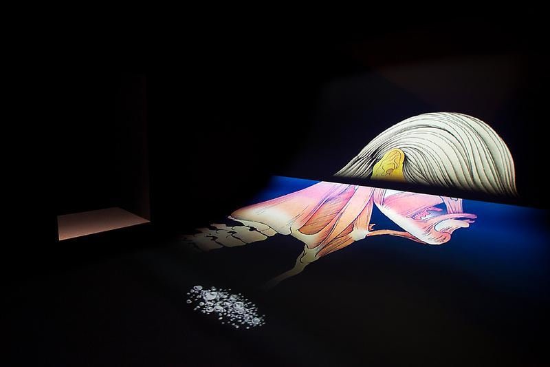 curved room with a video projection spanning the wall and floor