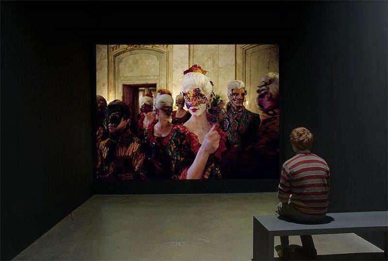 person sitting watching a film with a masked woman