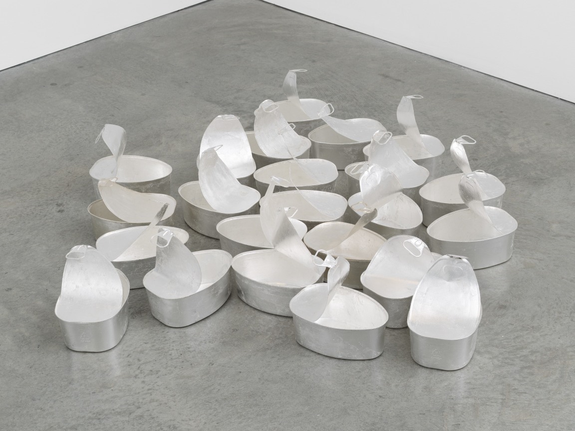 Image of an untitled sculpture by Michelle Grabner consisting 20 oversized steel ham tins of silver leaf with natural tarnishing