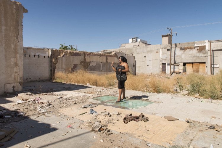Transgender sex worker standing on the dance floor of a demolished night club