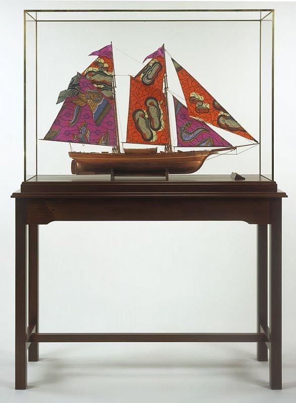ship with colorful sails inside of a glass case