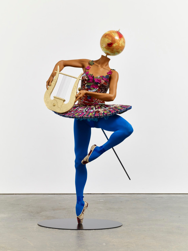 mannequin with a globe for a head dancing ballet and holding a lyre