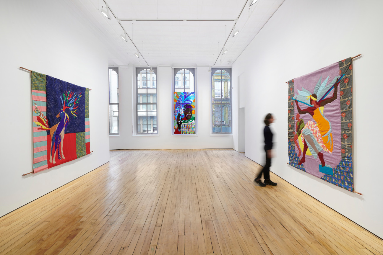 person walking through a gallery full of artworks