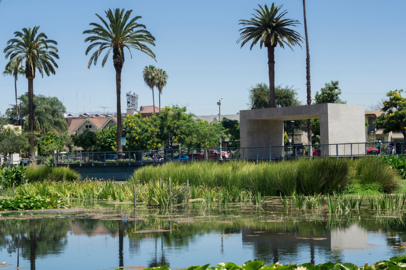 concrete structure facing a marsh-like landscape in a suburban area