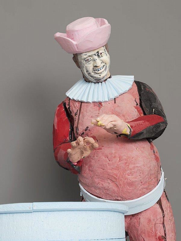 happy statue holding out his hands over a barrel as if warming them over a fire