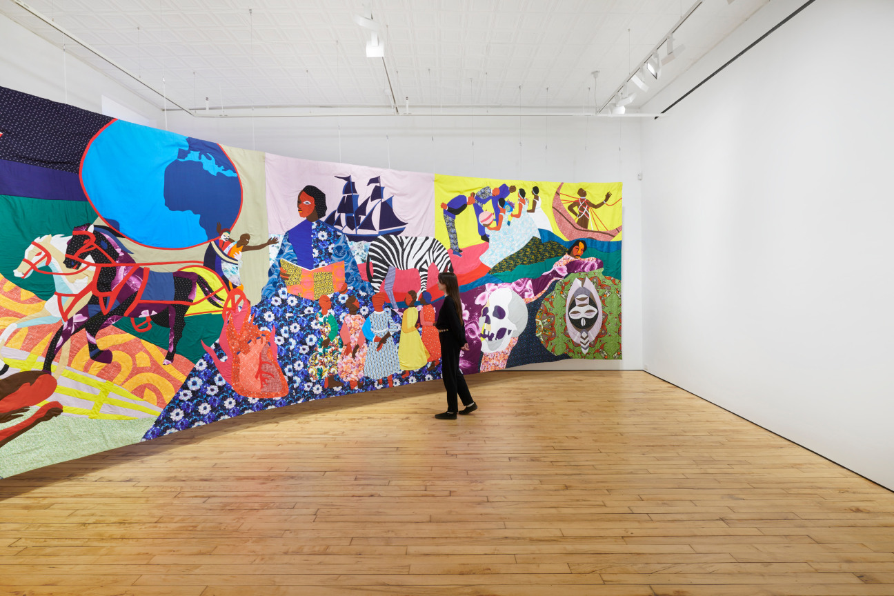 an individual looking at a large tapestry