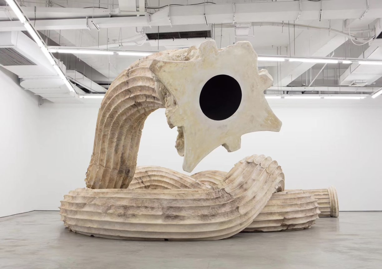 frontal view of a Greek corinthian column curled up in a snake-like pose, focused on the viewer