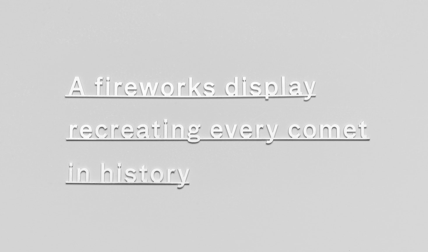 text made of Micro waterjet-cut sterling silver attached to a plain white wall