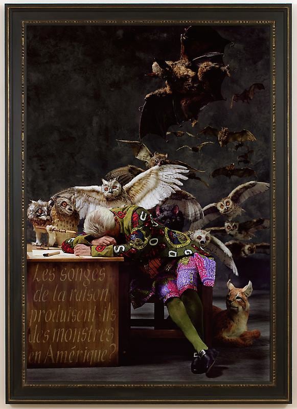 white man asleep on his desk with several animals behind him