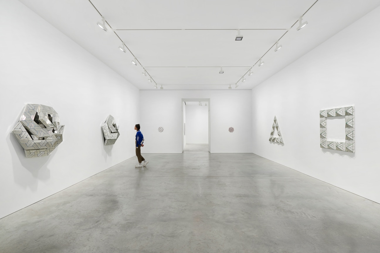 view of several glass artworks and a hallway leading to the next gallery in the center