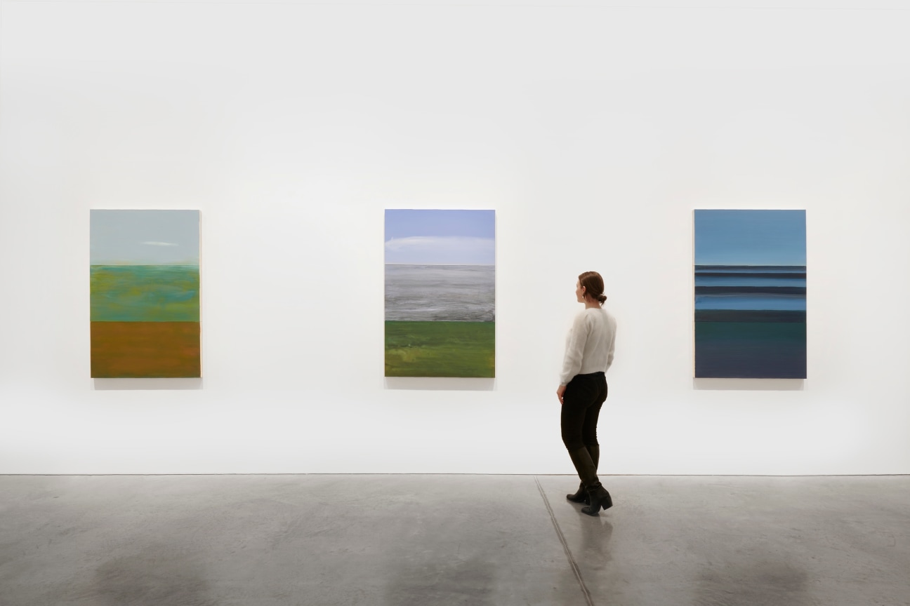 person viewing one of three paintings