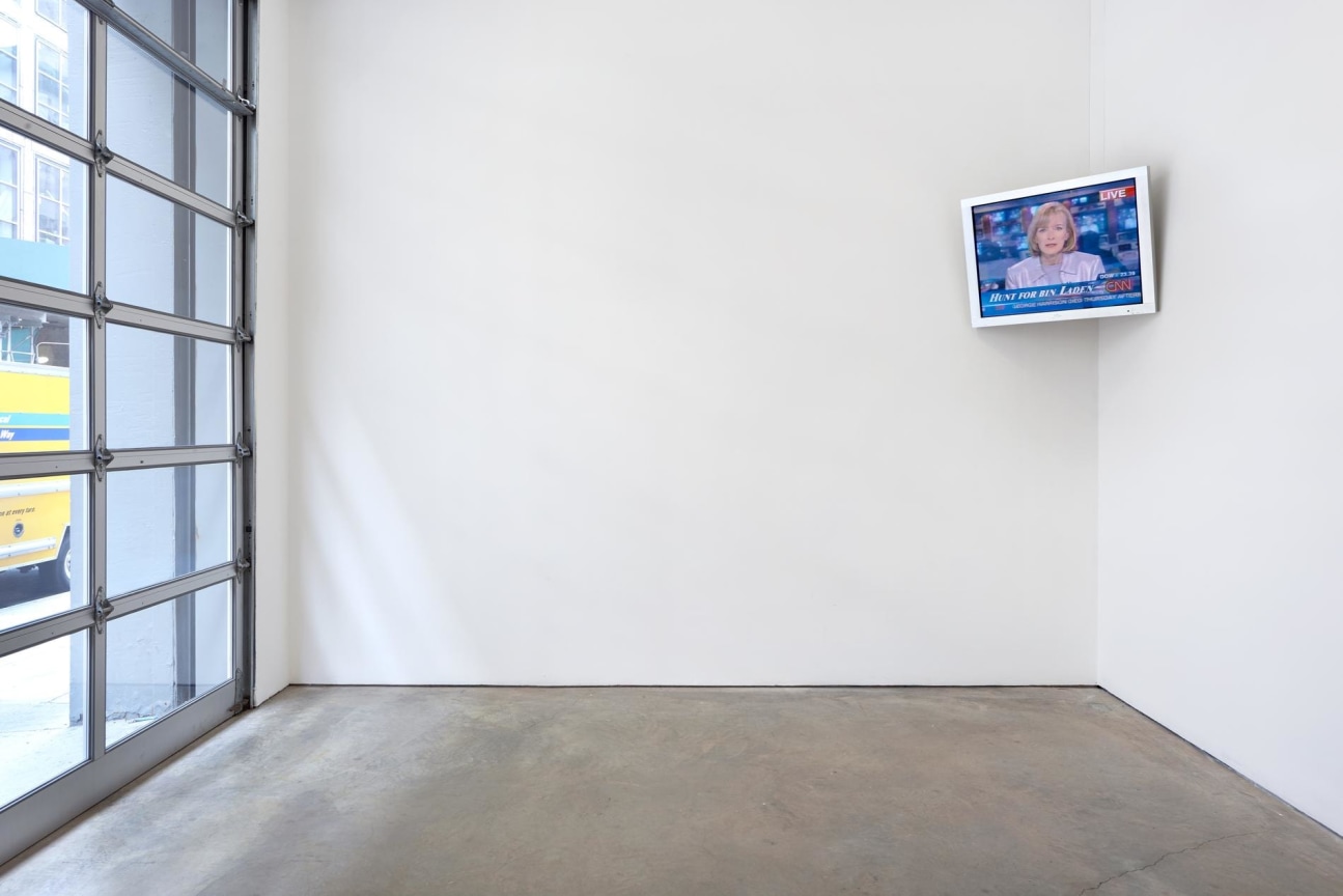 a television hanging from the corner of the room broadcasting the news channel
