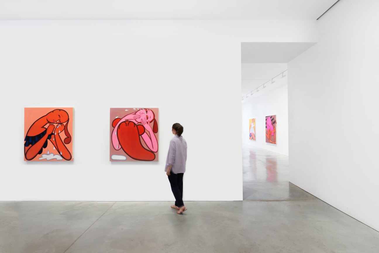 a figure observing two paintings of women crying